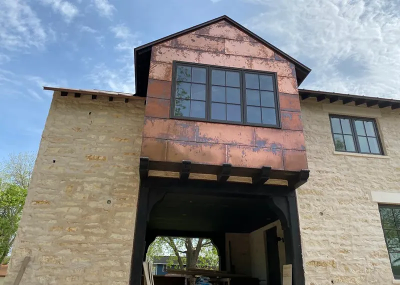 Copper metal panel facade on a stone building for Skylight Installation in Sun Village